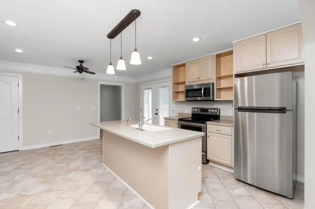 a kitchen with stainless steel appliances a refrigerator sink and microwave