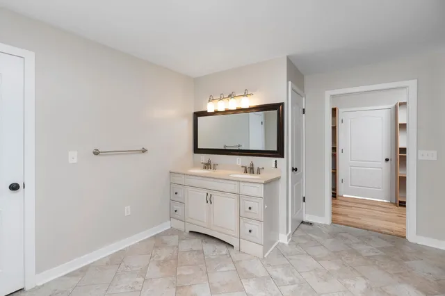 a bathroom with a tub sink and mirror