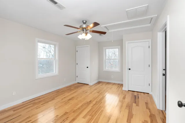 a view of empty room with window and ceiling fan