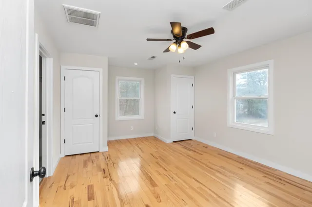a view of empty room with wooden floor