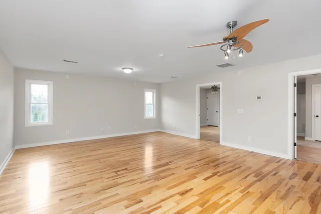a view of a kitchen with kitchen island white cabinets and wooden floor