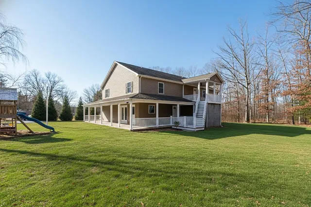 a view of a house with a yard and sitting area