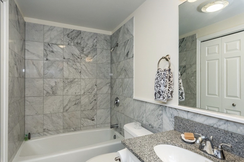 110 Cypress Street, Unit 307 Brookline, MA 02445 - Photo 15 of 24 a bathroom with a granite countertop sink and a mirror