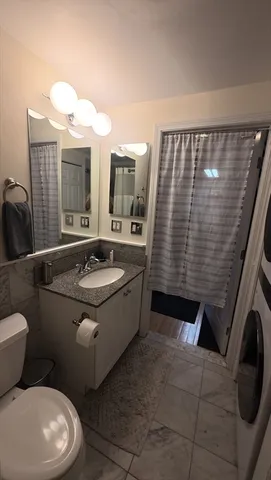 a bathroom with a sink a toilet and mirror
