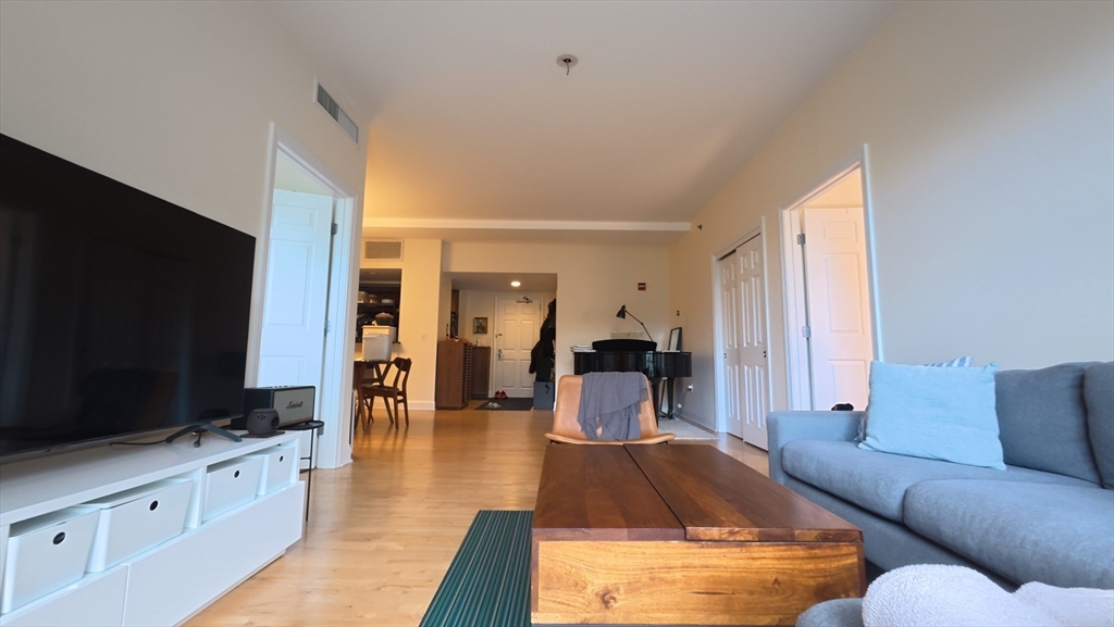 110 Cypress Street, Unit 307 Brookline, MA 02445 - Photo 2 of 24 a living room with furniture and a flat screen tv