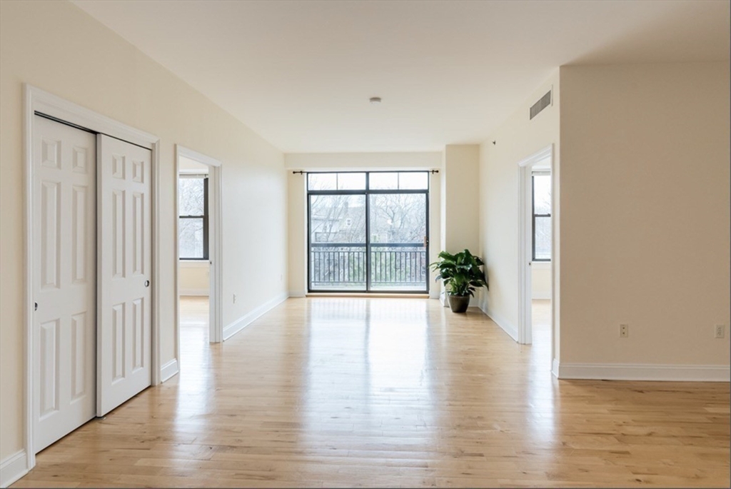 110 Cypress Street, Unit 307 Brookline, MA 02445 - Photo 3 of 24 a view of an empty room with wooden floor and a window