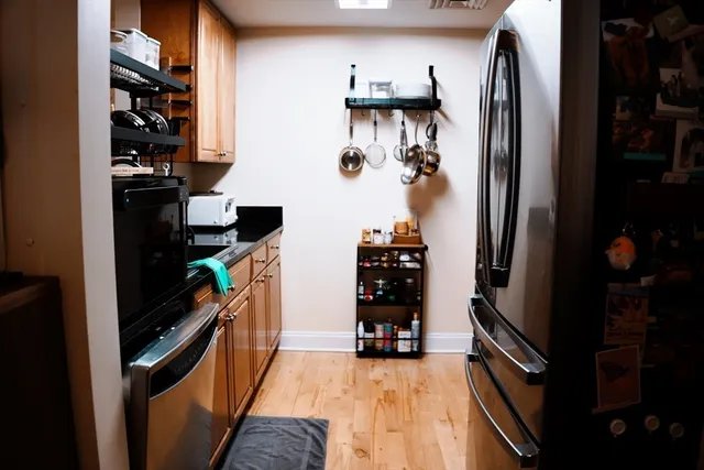 a kitchen with stainless steel appliances a refrigerator and a wooden floor