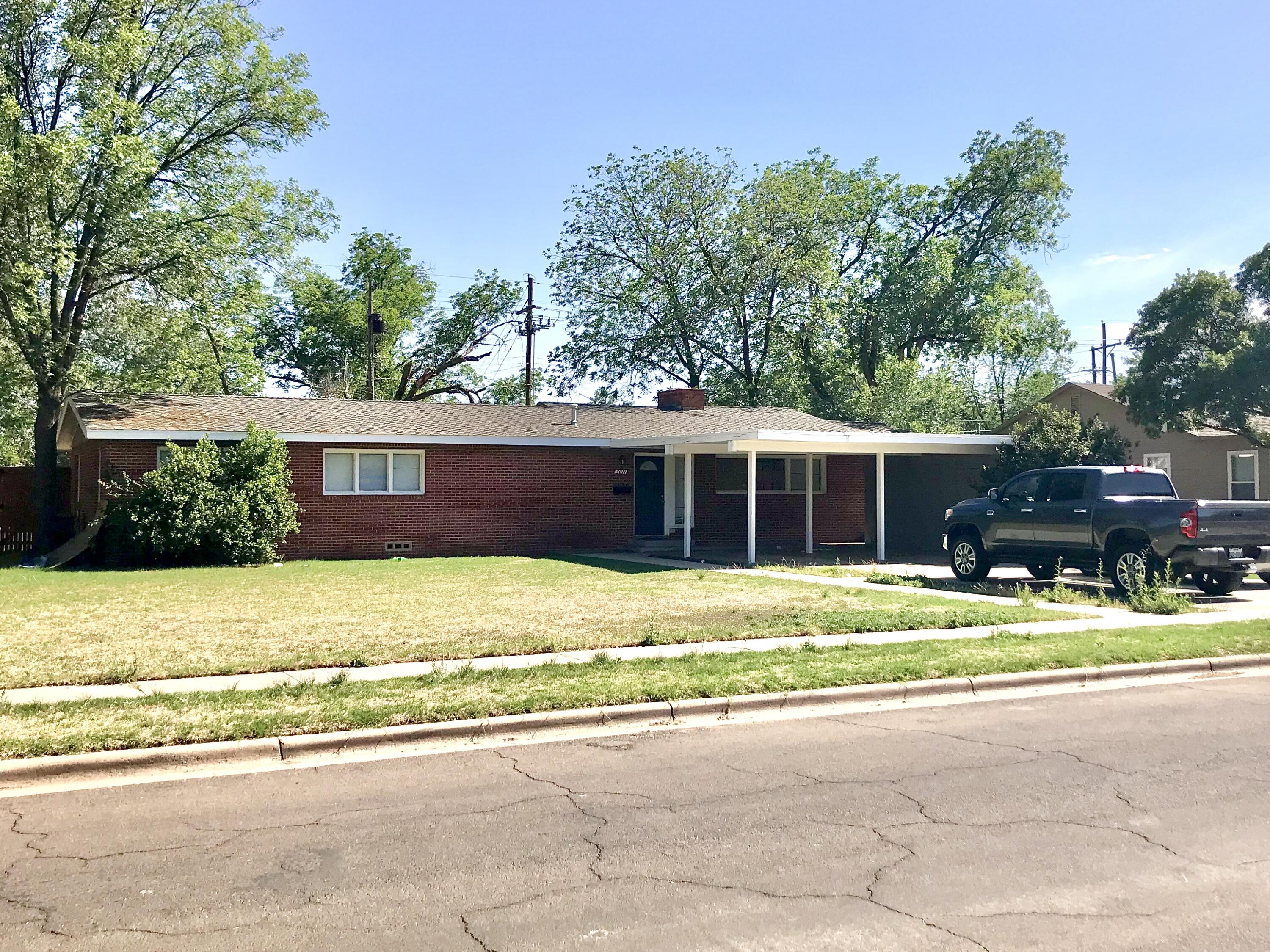 a front view of a house with a yard and trees