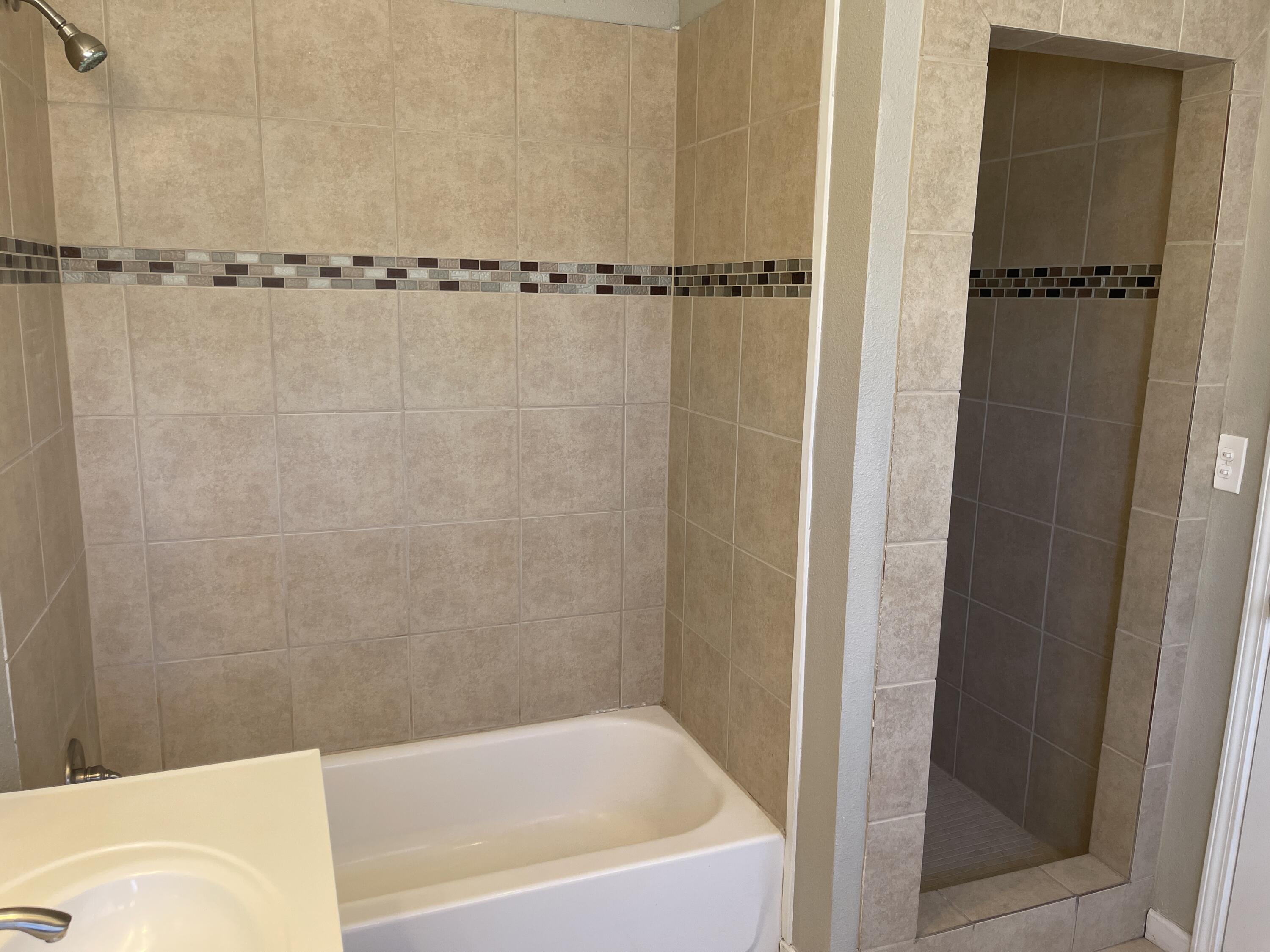 3011 32nd Street Lubbock, TX 79410 - Photo 15 of 16 a bathroom with a bathtub and a shower