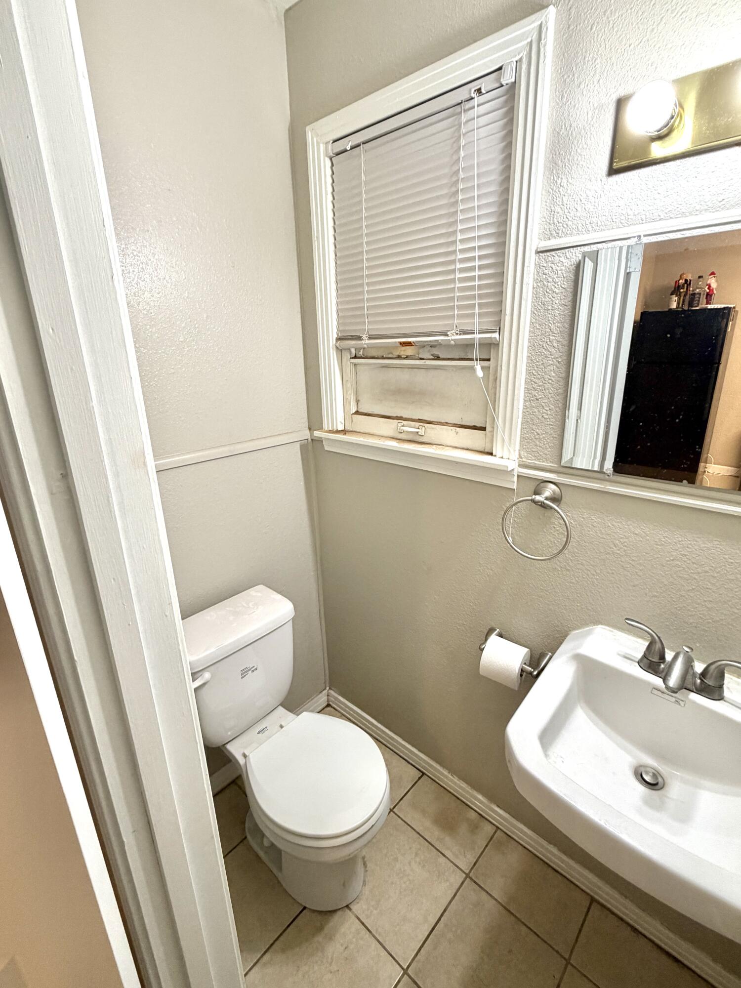 3011 32nd Street Lubbock, TX 79410 - Photo 7 of 16 a bathroom with a sink and a toilet