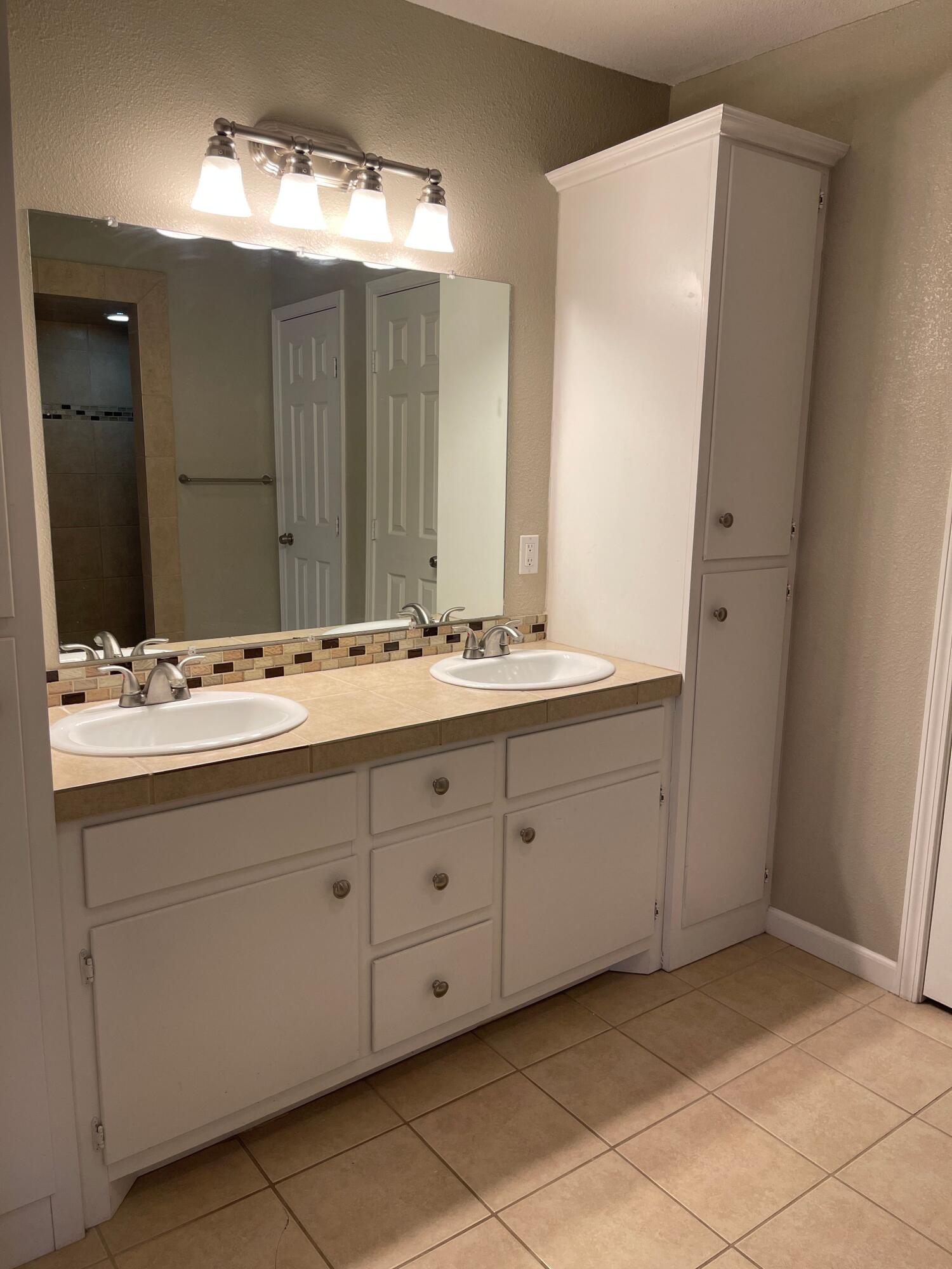3011 32nd Street Lubbock, TX 79410 - Photo 8 of 16 a bathroom with a double vanity sink and a mirror