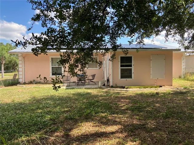 a backyard of a house with table and chairs