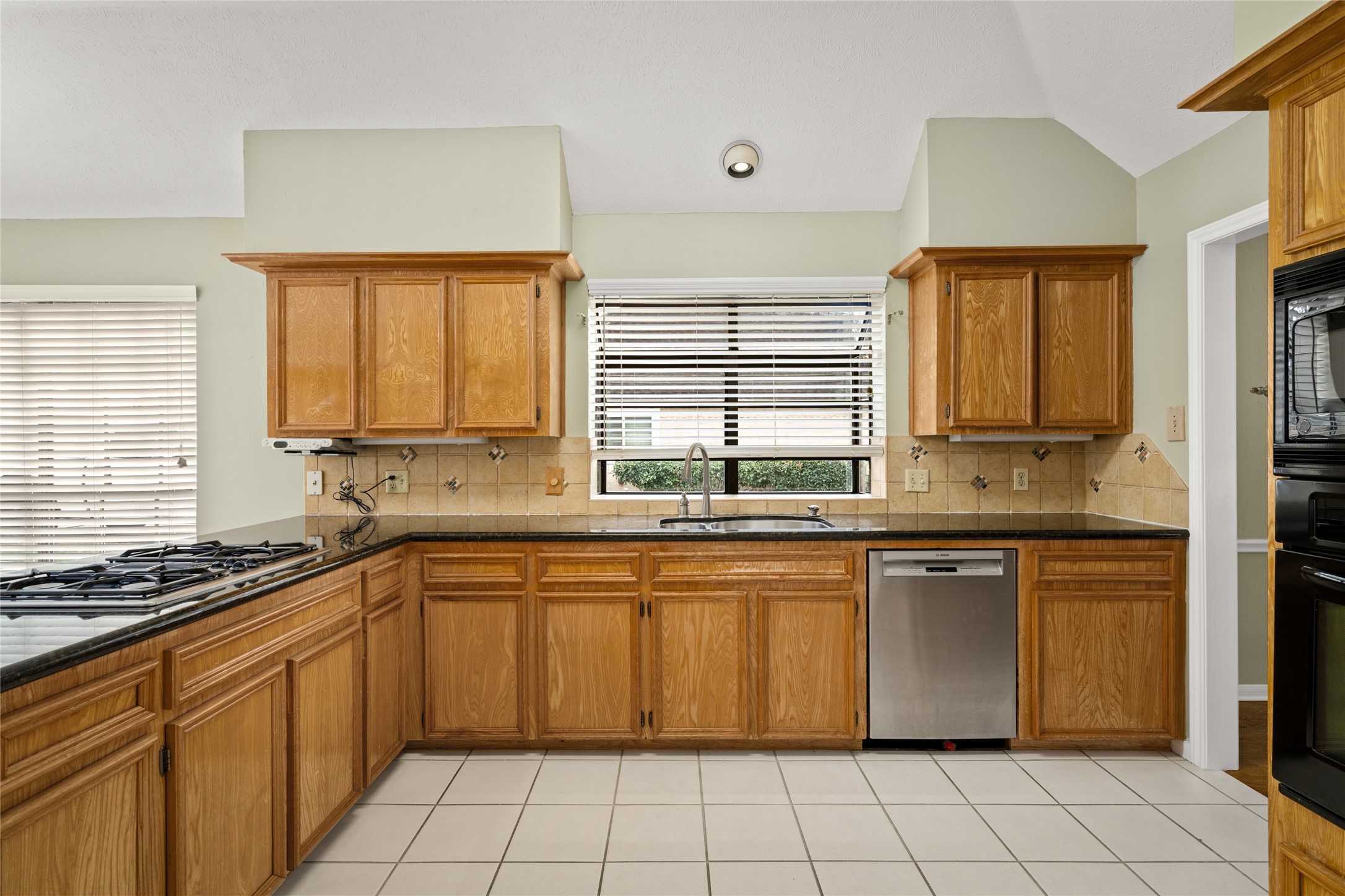 16106 Ridge Park Drive Houston, TX 77095 - Photo 10 of 23 a kitchen with stainless steel appliances granite countertop a sink counter space cabinets and a large window