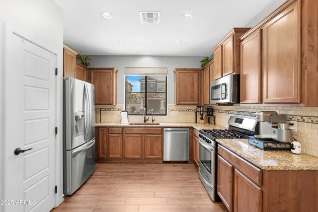 a kitchen with stainless steel appliances granite countertop a sink stove and refrigerator