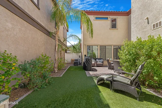 a view of a house with backyard and sitting area