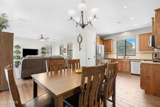 a view of a dining room with furniture a chandelier and wooden floor