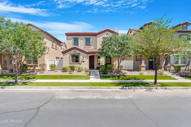 a front view of a house with a yard and potted plants
