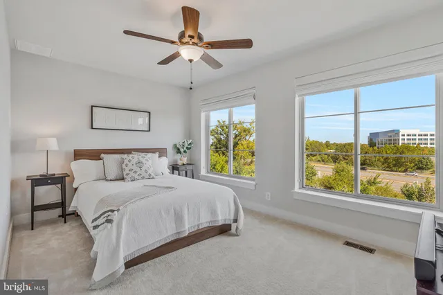 a bedroom with a bed and a large window