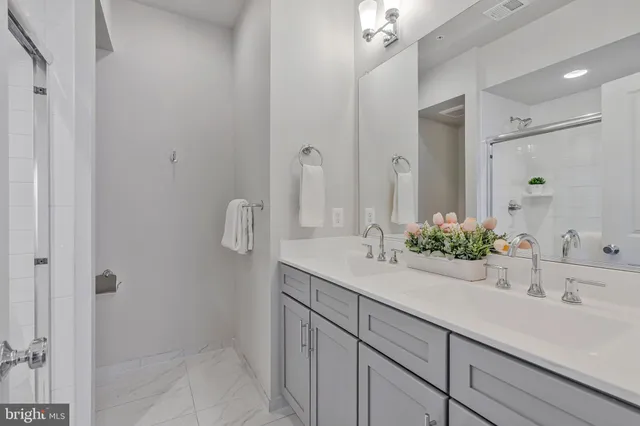 a bathroom with a sink and mirror with shower
