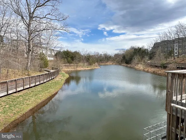 a view of a big building in front of a big yard and large trees