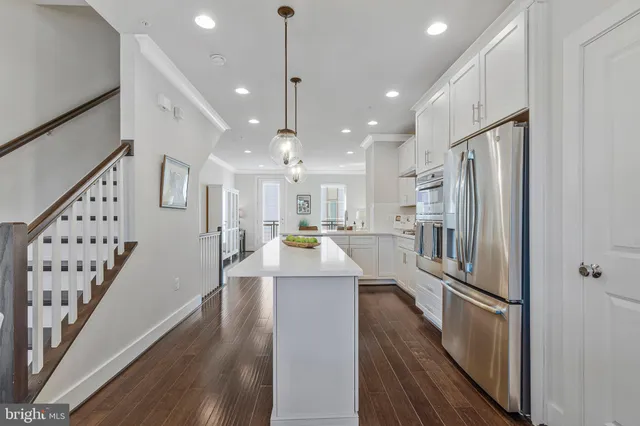 a view of a kitchen with wooden floor and electronic appliances