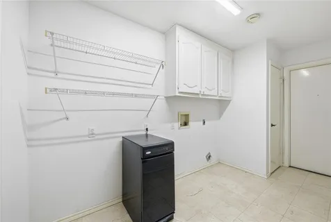 a view of cabinets and utility room with empty racks
