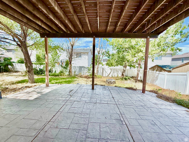 1705 80 East Tooele, UT 84074 - Photo 20 of 22 Covered patio featuring a stamped concrete surface, supported by exposed wood beams and posts