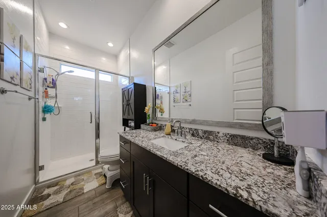 a bathroom with a granite countertop sink and a mirror