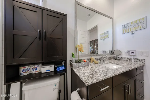 a bathroom with a granite countertop sink and a mirror