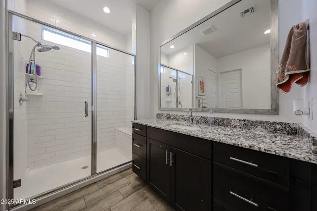 a bathroom with a granite countertop sink and a mirror