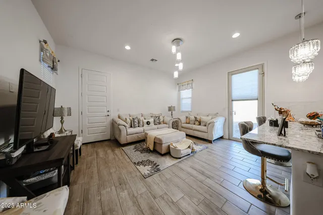 a living room with furniture wooden floor and a flat screen tv
