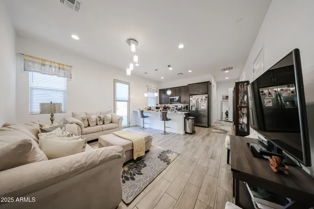 a living room with furniture flat screen tv and wooden floor
