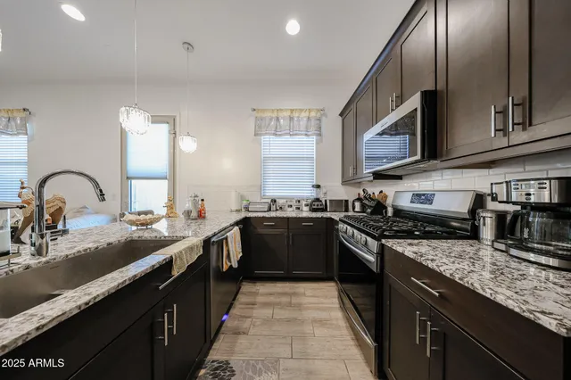 a kitchen with stainless steel appliances granite countertop a sink and stove