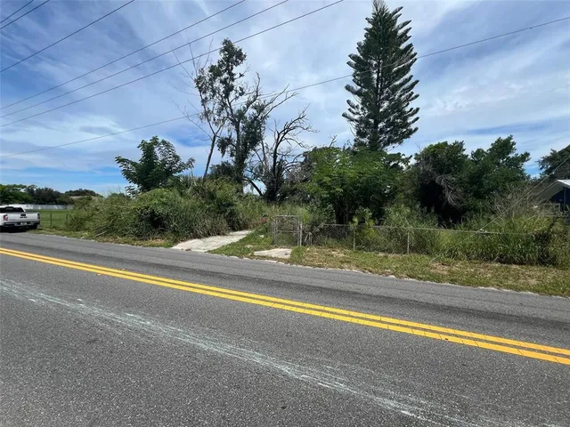 a view of a house with a yard and palm trees
