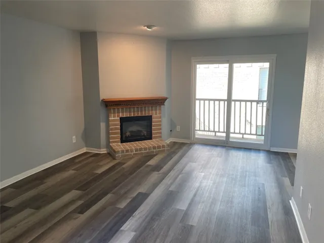 wooden floor fireplace and windows in an empty room