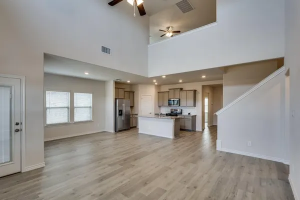 a view of a living room and kitchen with furniture and wooden floor