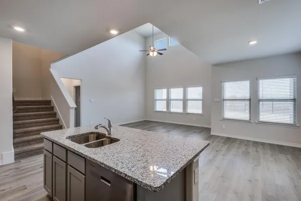 a kitchen with a sink a counter space and wooden floor