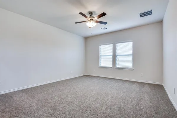 an empty room with closet and ceiling fan