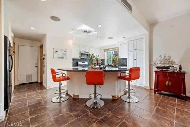 a kitchen with stainless steel appliances kitchen island granite countertop a stove a refrigerator and cabinets