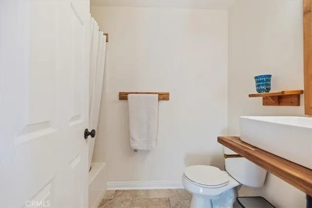 a white toilet sitting next to a shower