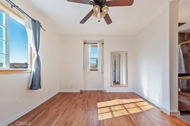 a view of an empty room with window and wooden floor