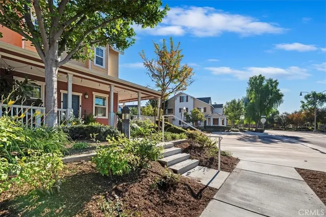 a view of a house with a yard and potted plants