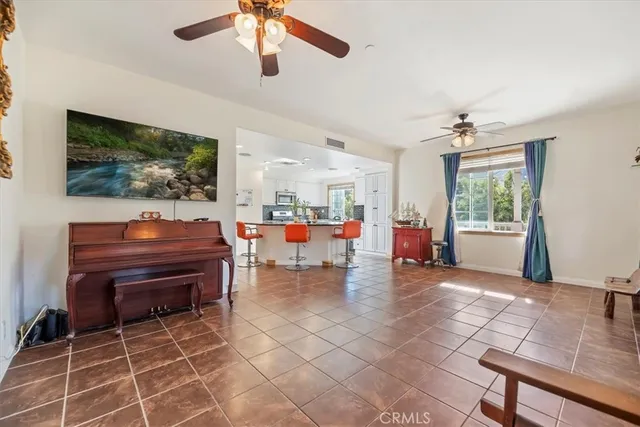 a living room with furniture and a flat screen tv with kitchen view
