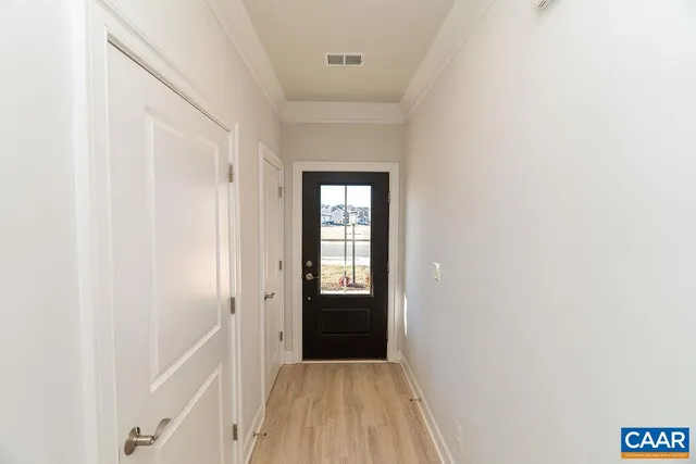 a view of a hallway with wooden floor and entryway
