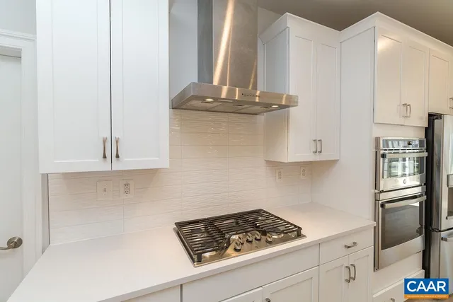a kitchen with granite countertop stainless steel appliances a stove and a refrigerator