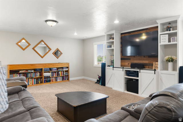 2485 South 1100th Street West Logan, UT 84321 - Photo 28 of 53 Entertainment area featuring built-in shelving, a wood accent wall, and white barn-door style cabinetry
