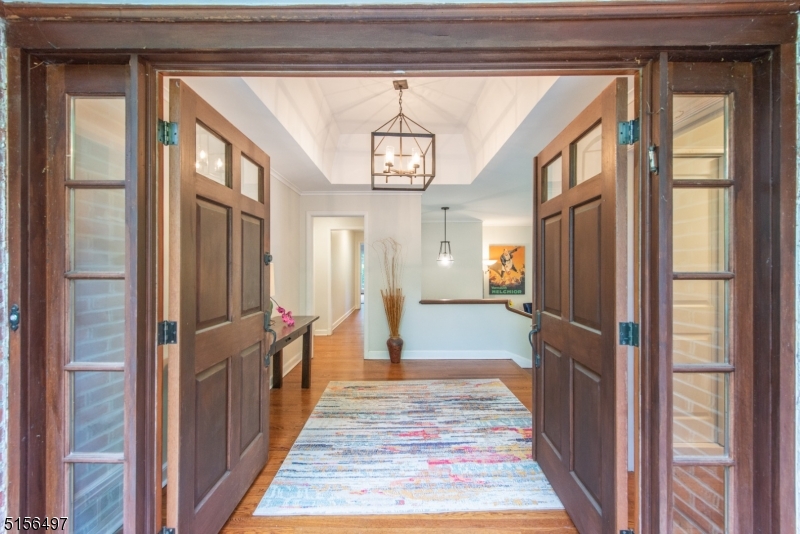 32 Parsonage Hill Road Short Hills, NJ 07078 - Photo 2 of 49 a hallway with a large window and a chandelier