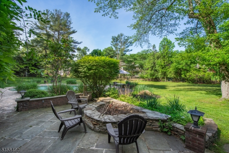 32 Parsonage Hill Road Short Hills, NJ 07078 - Photo 39 of 49 a view of a lake with table and chairs potted plants and large trees
