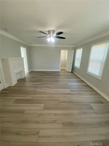 a kitchen with stainless steel appliances granite countertop a refrigerator a sink and white cabinets with wooden floor