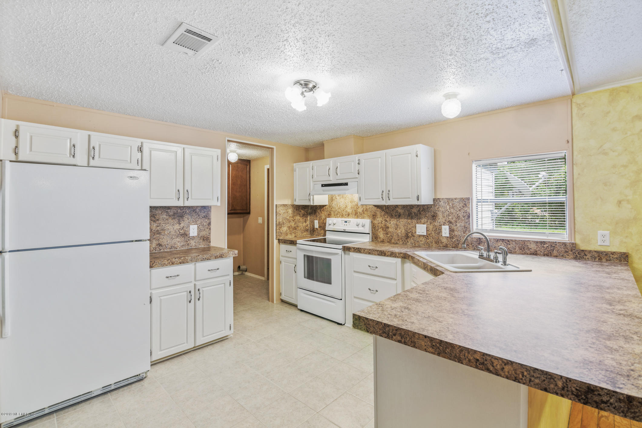 1665 Scott Road St. Johns, FL 32259 - Photo 35 of 54 a kitchen with granite countertop white cabinets and white appliances